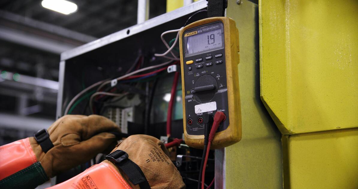 Electrician verificând un panou de control electric